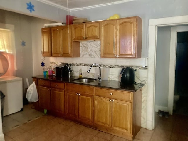 kitchen featuring light tile patterned flooring, sink, and backsplash