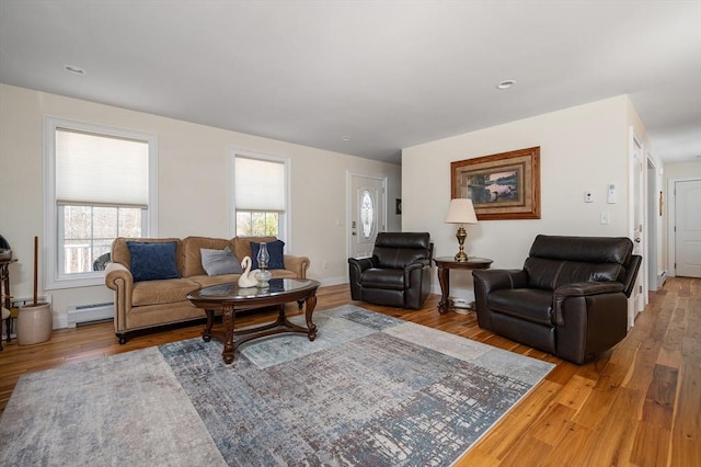 living room with a baseboard radiator, baseboards, and wood finished floors