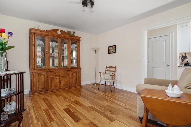 living area featuring light wood-type flooring and baseboards