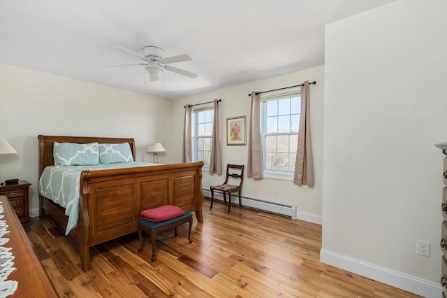 bedroom with a baseboard heating unit, baseboards, light wood-style floors, and ceiling fan