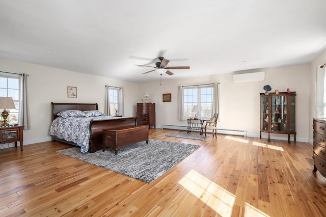 bedroom with a ceiling fan, baseboards, a baseboard radiator, an AC wall unit, and light wood-type flooring