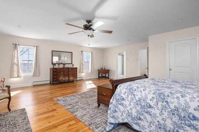 bedroom with baseboards, multiple windows, and wood finished floors