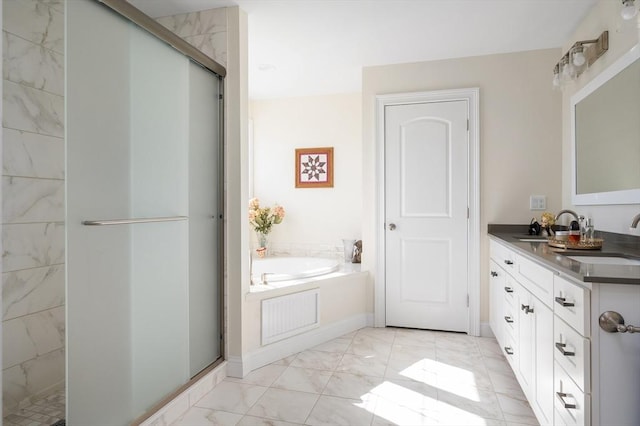 full bath with double vanity, a shower stall, a garden tub, and a sink