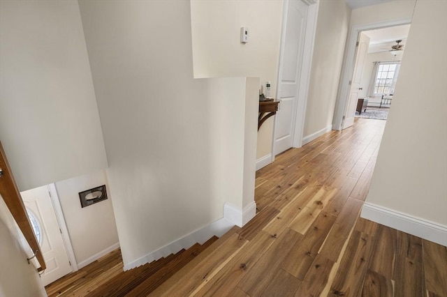 corridor with hardwood / wood-style floors and baseboards