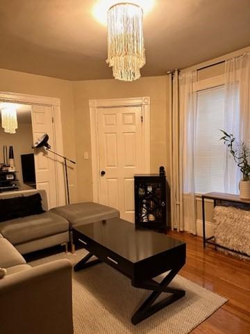 living room with hardwood / wood-style flooring and a notable chandelier