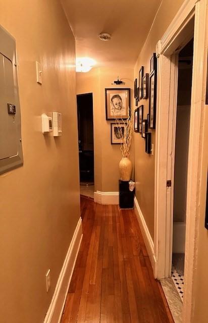 corridor with dark hardwood / wood-style flooring