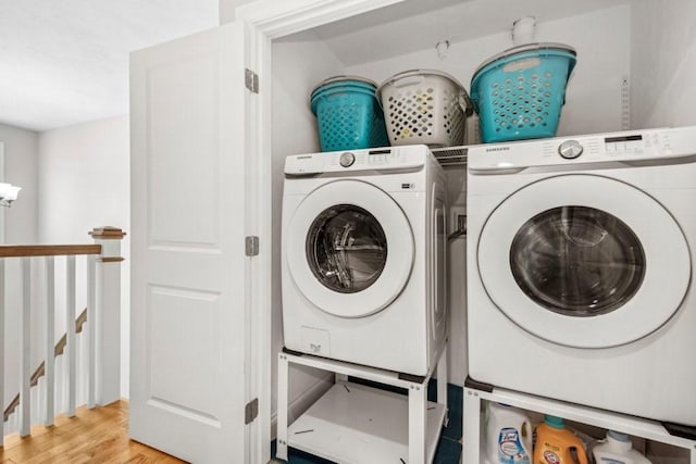 laundry area with separate washer and dryer and light wood-type flooring