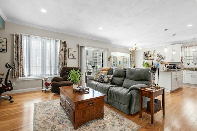 living room with ornamental molding, plenty of natural light, light hardwood / wood-style floors, and a chandelier