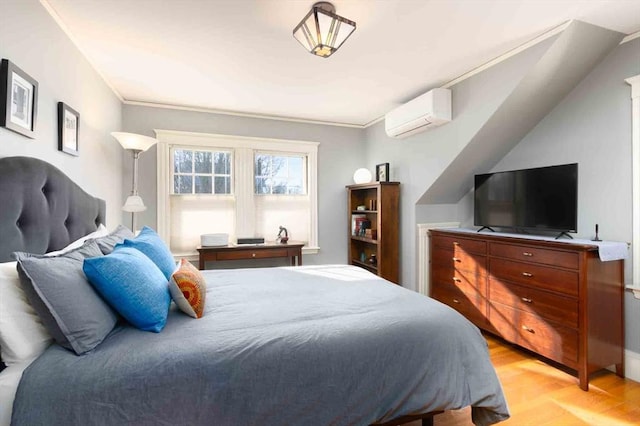 bedroom with light wood-style floors, a wall unit AC, and crown molding