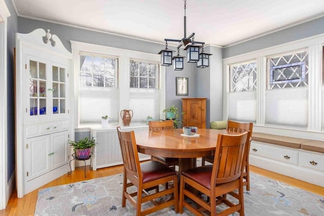 dining room featuring crown molding and light wood-style flooring