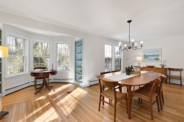 dining room featuring a baseboard radiator, a wealth of natural light, and light hardwood / wood-style flooring