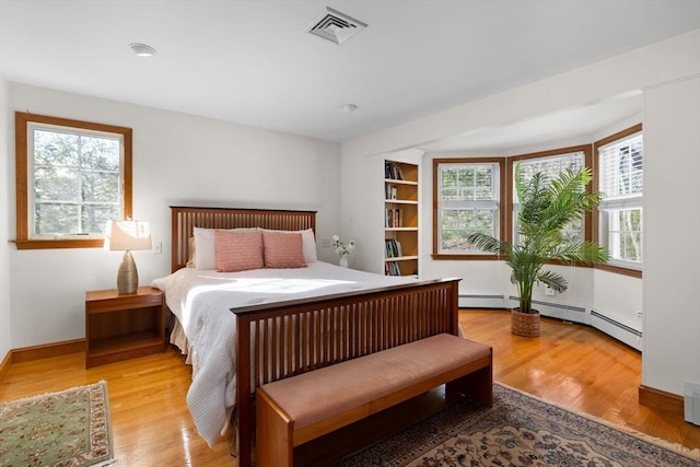 bedroom with multiple windows and light hardwood / wood-style flooring