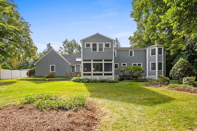 rear view of property featuring a yard and a sunroom