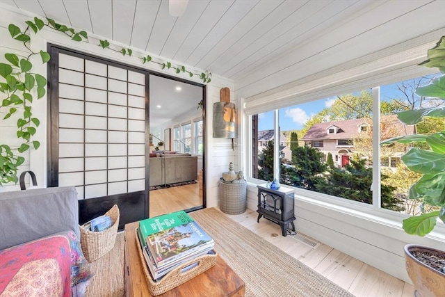 interior space featuring wooden ceiling, a wood stove, and wood finished floors