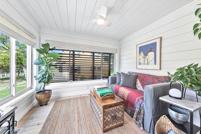 sunroom / solarium featuring a healthy amount of sunlight, wooden ceiling, wood walls, and wood finished floors