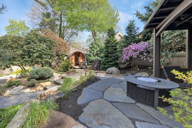 view of yard featuring a patio, fence, and an outdoor fire pit
