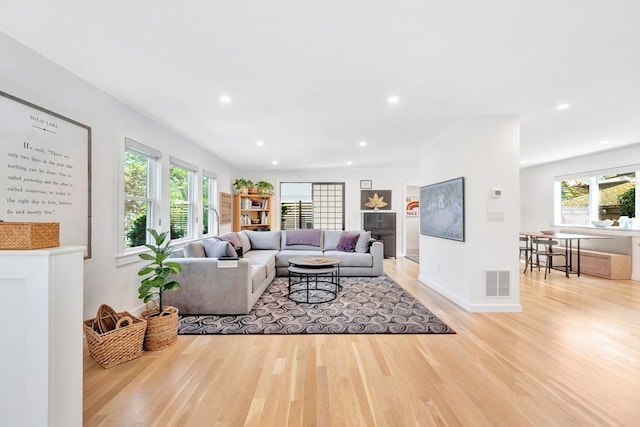 living area with baseboards, recessed lighting, light wood-style flooring, and visible vents
