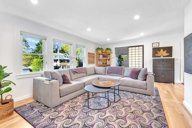 living area with recessed lighting, baseboards, and light wood finished floors