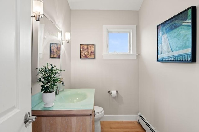 32 Northern Blvd, Newbury, MA 01951 - half bath featuring vanity, wood finished floors, toilet, baseboards, and a baseboard radiator