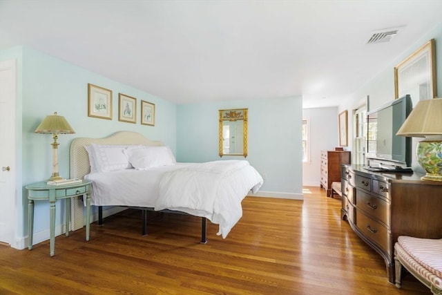bedroom featuring wood finished floors and baseboards