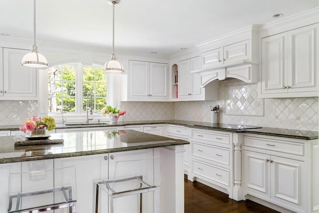 kitchen with white cabinetry, black electric cooktop, dark stone counters, and crown molding