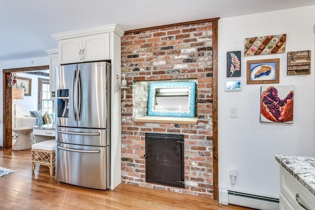 315 Pleasant St, Chatham, MA 02659 - kitchen with stainless steel refrigerator with ice dispenser, a baseboard radiator, white cabinets, light wood-type flooring, and light stone counters