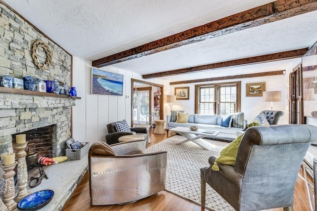 315 Pleasant St, Chatham, MA 02659 - living room featuring a textured ceiling, wood finished floors, beam ceiling, and a fireplace