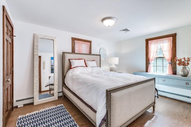315 Pleasant St, Chatham, MA 02659 - bedroom with wood finished floors and a baseboard heating unit