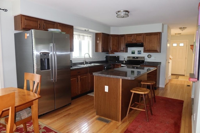 12 Sterling Ln Unit 12, Walpole, MA 02081 - kitchen featuring appliances with stainless steel finishes, a sink, ventilation hood, dark countertops, and light wood-style flooring