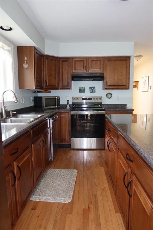 12 Sterling Ln Unit 12, Walpole, MA 02081 - kitchen featuring appliances with stainless steel finishes, under cabinet range hood, a sink, light wood-style floors, and brown cabinetry