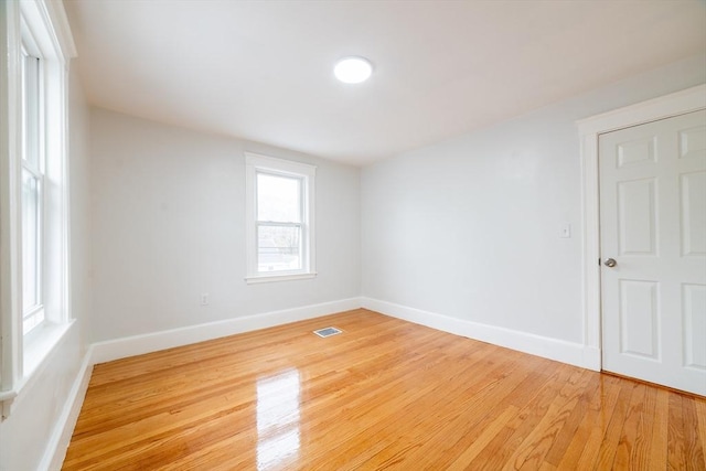 spare room with baseboards, visible vents, and light wood-type flooring