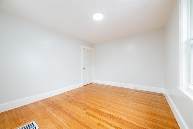 unfurnished room featuring baseboards, visible vents, and light wood-style flooring