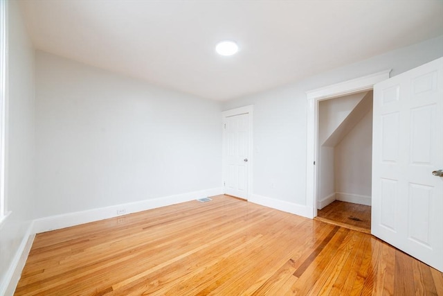 unfurnished bedroom with visible vents, light wood-type flooring, a closet, and baseboards