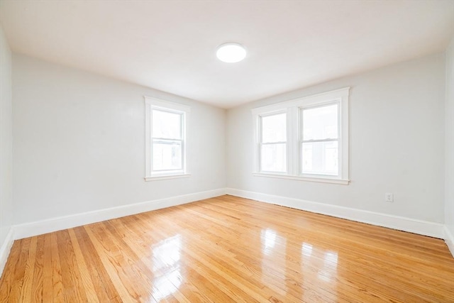 empty room featuring baseboards and light wood-style flooring