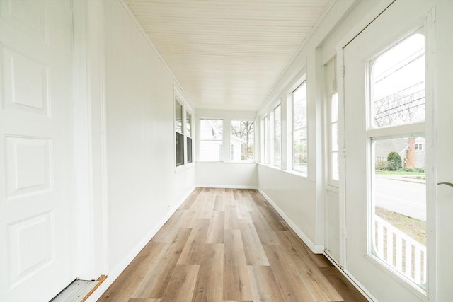 unfurnished sunroom with wood finished floors and baseboards