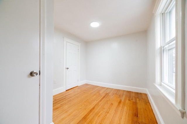 unfurnished room featuring baseboards and light wood-style floors