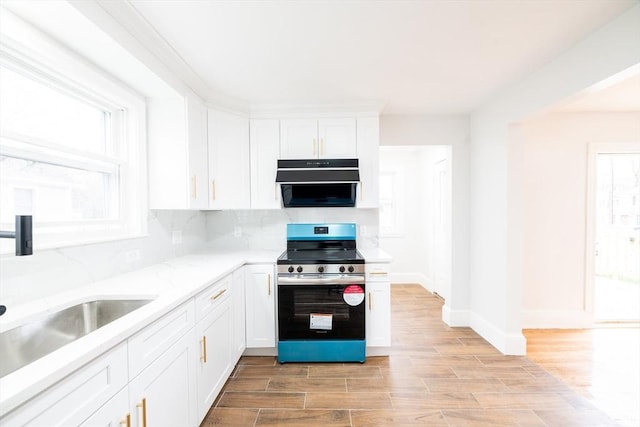 kitchen with white cabinets, plenty of natural light, electric range, and a sink