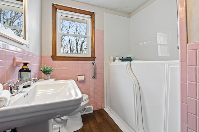 bathroom featuring wood finished floors, visible vents, a wealth of natural light, and a sink