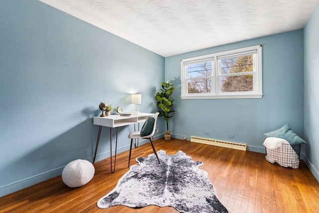 office featuring baseboards, wood-type flooring, and baseboard heating