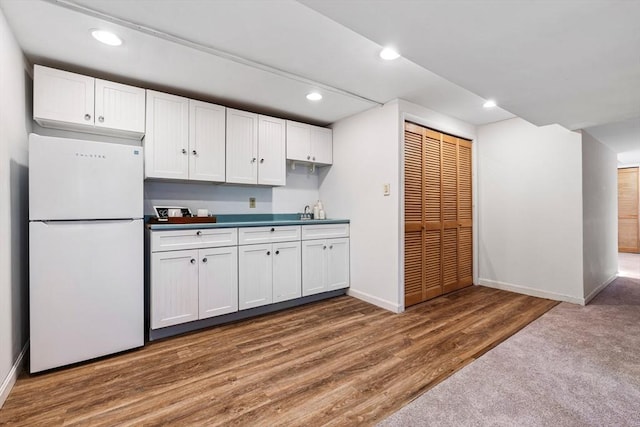 kitchen with recessed lighting, freestanding refrigerator, baseboards, and wood finished floors