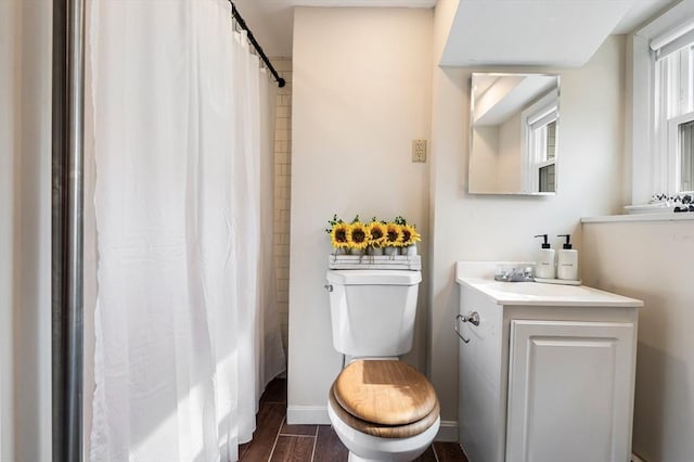 bathroom featuring a shower with curtain, toilet, wood finished floors, baseboards, and vanity