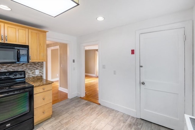 kitchen with black appliances, dark stone countertops, light brown cabinets, light hardwood / wood-style floors, and backsplash