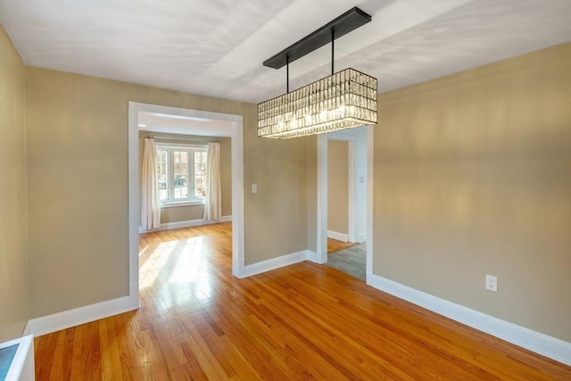 unfurnished dining area featuring wood-type flooring and a chandelier