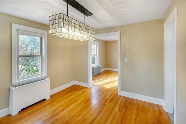 unfurnished dining area with radiator and light wood-type flooring