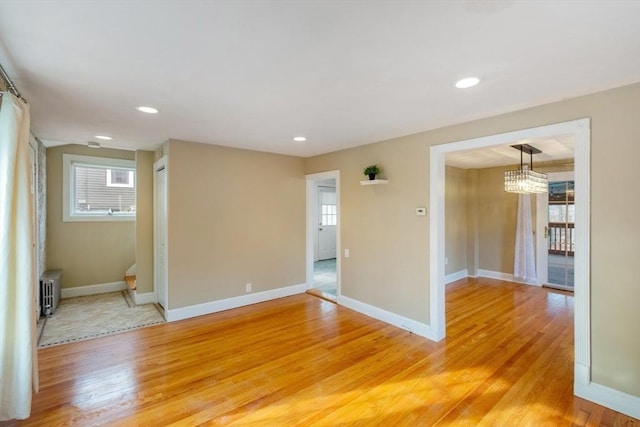 empty room with hardwood / wood-style floors and radiator heating unit