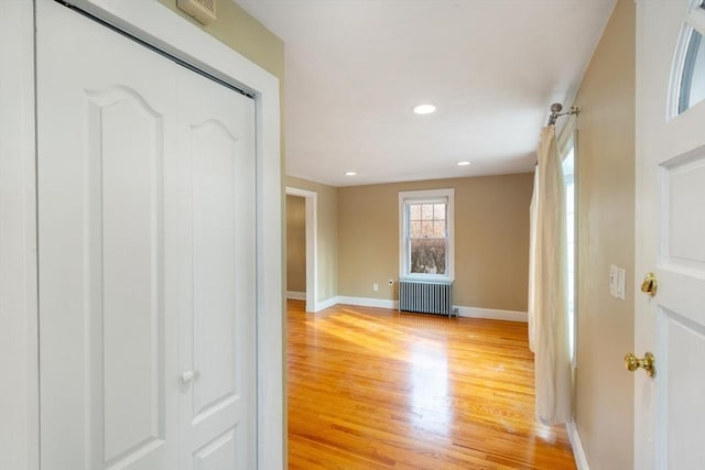 corridor featuring radiator and light hardwood / wood-style flooring