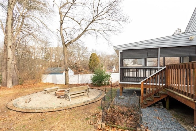 view of yard featuring a shed, a deck, and a fire pit