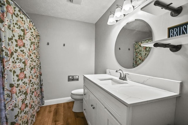 11 Fernwood Dr Unit D, Leominster, MA 01453 - full bath with wood finished floors, toilet, baseboards, vanity, and a textured ceiling
