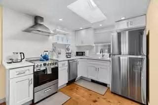 168 N Shore Blvd Unit 12, Sandwich, MA 02537 - kitchen featuring recessed lighting, light countertops, wall chimney exhaust hood, a skylight, and stainless steel appliances