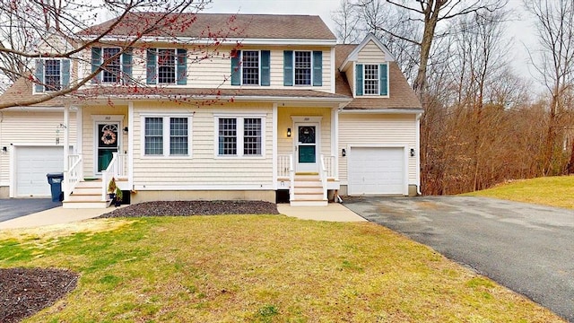 view of front of home featuring driveway, a shingled roof, a garage, and a front yard